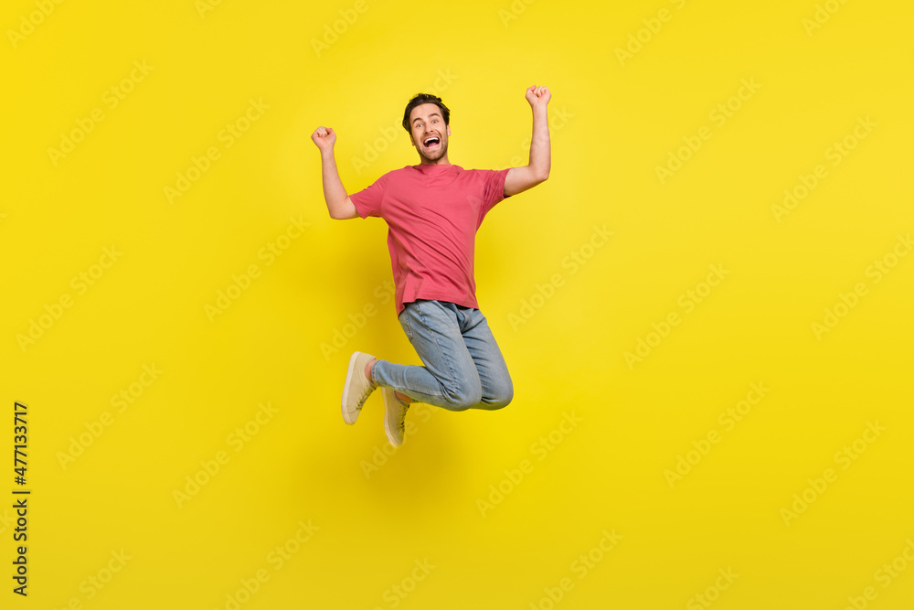 Full body photo of cool brunet millennial guy jump yell wear t-shirt jeans shoes isolated on yellow background