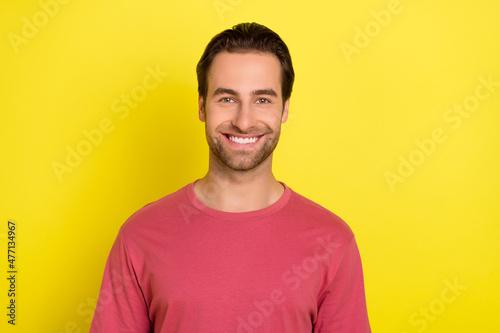 Photo of positive handsome bearded guy look camera shiny smile wear pink t-shirt isolated yellow color background © deagreez