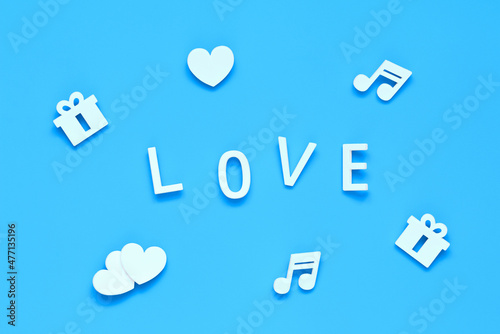 word LOVE, gifts, hearts and music notes on a blue background