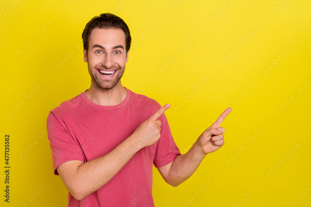 Photo of excited reliable guy indicate forefinger empty space sale wear pink t-shirt isolated yellow color background Photo of excited reliable guy indicate forefinger empty space sale wear pink t-shirt isolated yellow color background