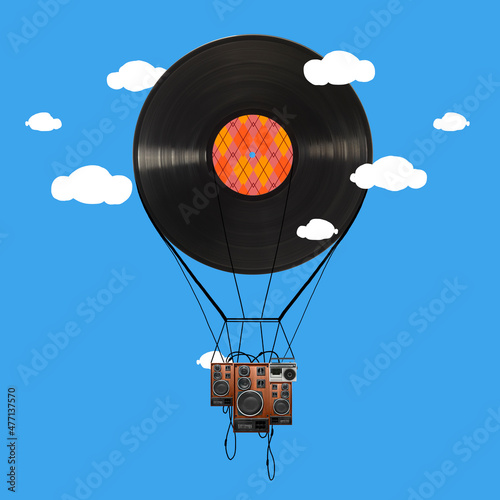 Contemporary art c ollage. Vinyl record on shape of air balloon with stereo speakers flying around blue background photo