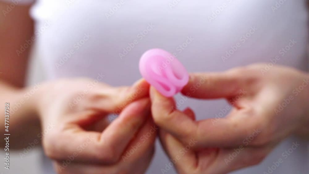Female hands show using menstrual cup close up. Woman hand holding menstrual cup. Female intimate hygiene period zero waste products. Women health concept. Female hands show using menstrual cup close up. Woman hand holding menstrual cup. Female intimate hygiene period zero waste products. Women health concept.