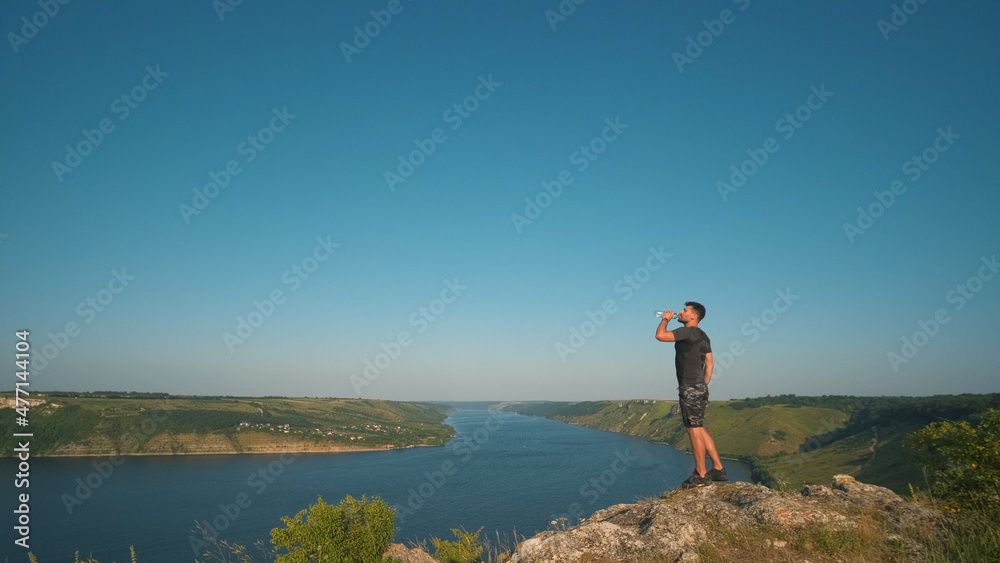 The man drinking water on a beautiful river background