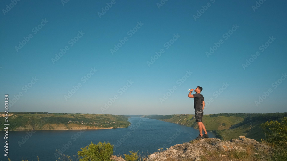 Fototapeta premium The man drinking water on a beautiful river background
