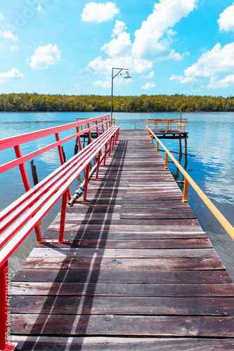 View of the lake with a wooden footbridge in the center of the photo. 