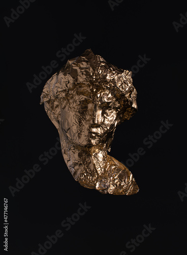 Gold tin foil shaped like classic antique sculpture against dark background. Popular, cultural products, tourist's attractions.