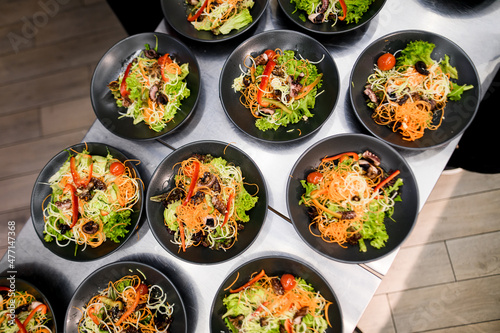 top view of plates with delicious salad with vegetables greens and lettuce and seafood