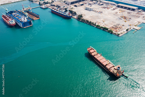 Aerial top view Tugboat drag Oil ship tanker on green sea going to shipyard repair