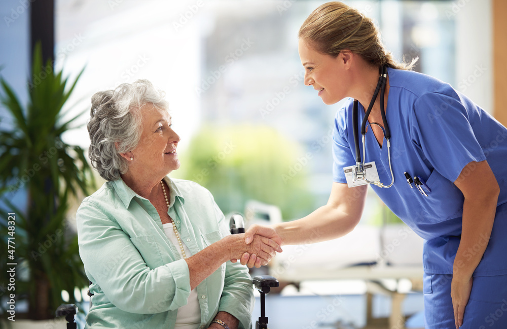 Obraz premium Shot of a doctor shaking hands with a smiling senior woman sitting in a wheelchair