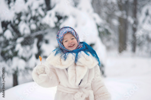 Carta da parati A girl in a white fur coat and a Russian folk blue shawl with patterns holds a l