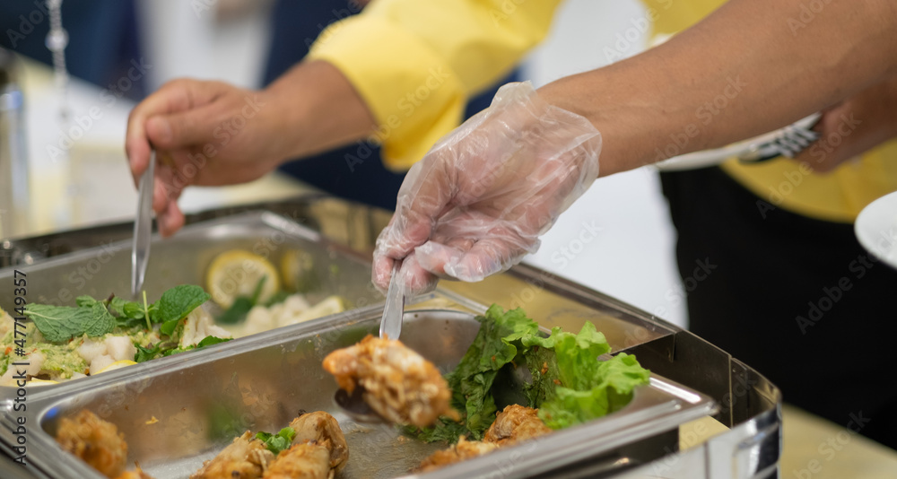 a person wearing gloves scooping food, catering, dinner time, prevent Coronavirus disease (covid 19)