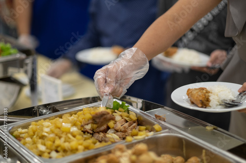 closeup hand wearing gloves scooping food, catering, dinner time, prevent Coronavirus disease (covid 19)