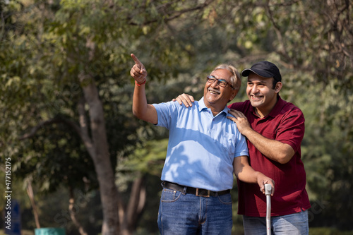 Cheerful grandfather spending leisure time with son at park  © G-images