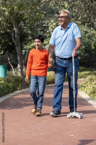 Wallpaper Mural Senior man holding stick while walking with grandson at park
 Torontodigital.ca