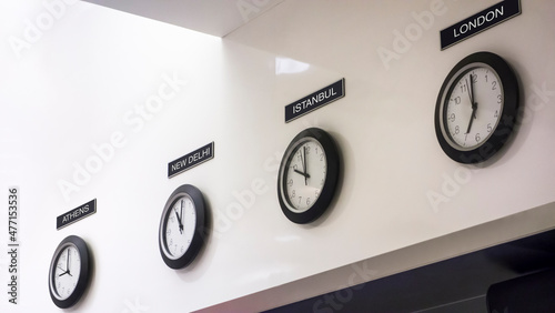Time zone clocks in a row on wall photo