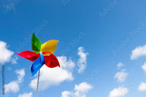 Colorful pinwheel blowing in wind against sky photo