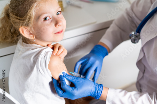 vaccination of children, a little girl at a doctor's appointment, an injection in the arm, the conce