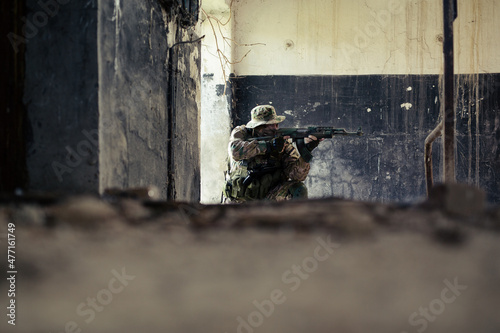 Airsoft solder on battlefield. Airsoft soldier with a rifle. photo