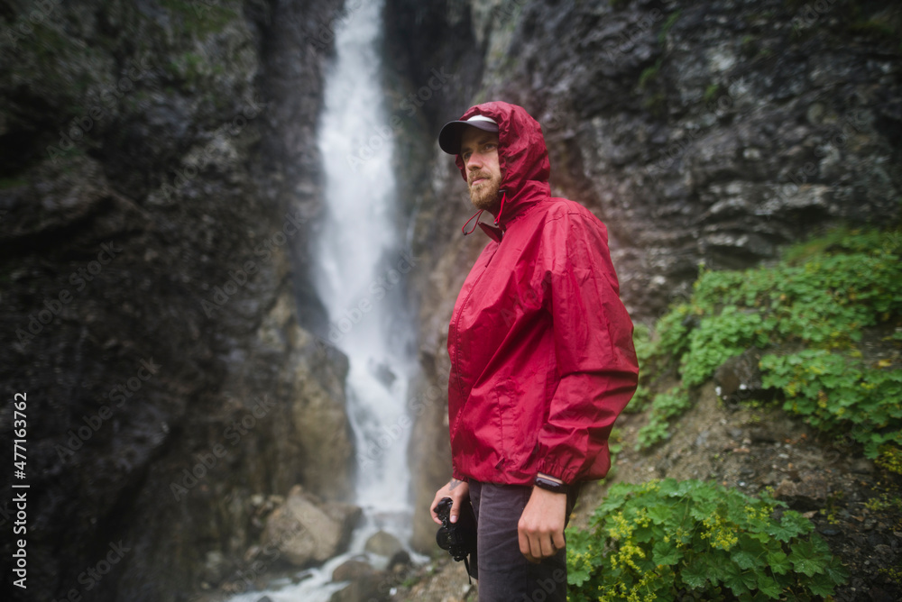 Russia , Karachay-Cherkessia, Arkhyz, Caucasus mountains, Hiker standing near waterfall Russia , Karachay-Cherkessia, Arkhyz, Caucasus mountains, Hiker standing near waterfall