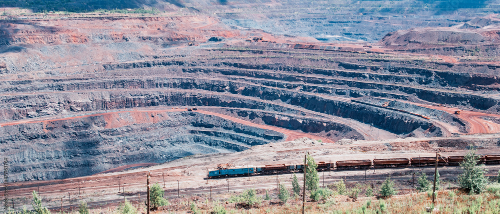 Iron ore extraction in the quarry of the Mikhailovsky mining and processing plant, a train travels inside the quarry