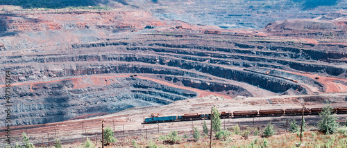Obraz na płótnie Iron ore extraction in the quarry of the Mikhailovsky mining and processing plant, a train travels inside the quarry w salonie