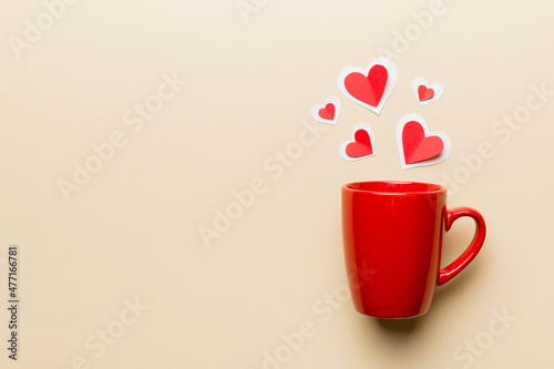 red cup on colored background, splashes of red little hearts, top view with copy space
