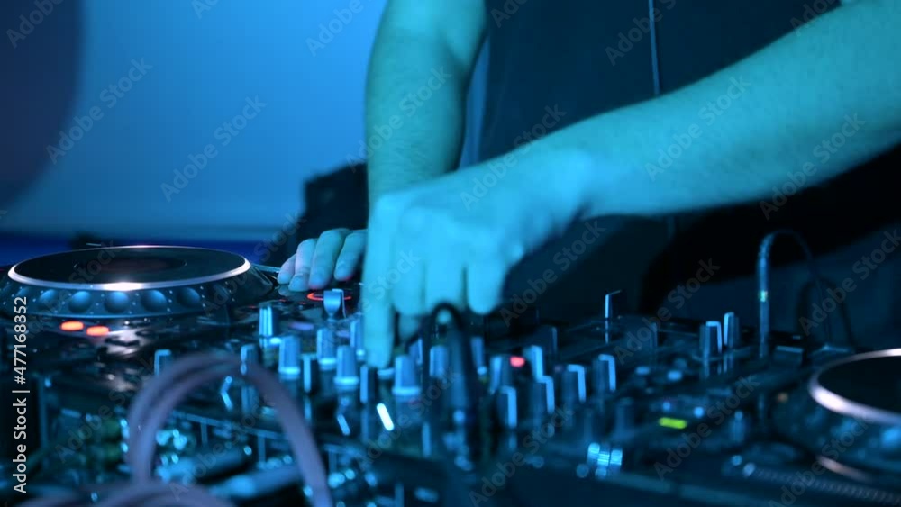 Close-Up of Dj Mixer Controller Desk in Night Club Disco Party. DJ Hands touching Buttons and Sliders Playing Electronic Music . High quality 4k footage