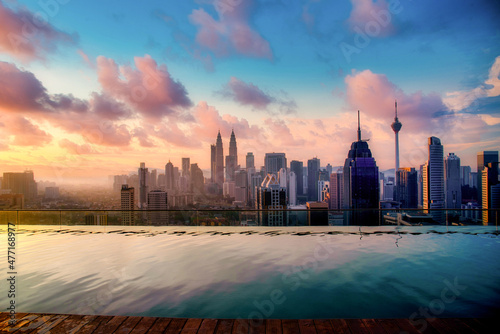 Cityscape of Kuala lumpur city skyline with swimming pool on the roof top of hotel at sunrise in Malaysia.