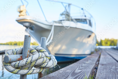 Rope with a knot close-up with a yacht in out-of-focus. Sea node © Татьяна Кутина