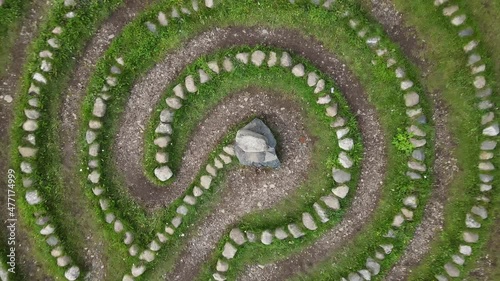 A round stone labyrinth with a top view, the camera rotates. photo