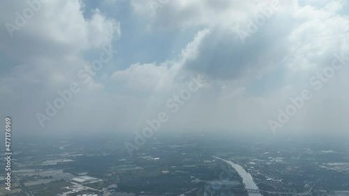 flying with blue sky day time view above little conutry side city with pollution and storm so far on horizon photo