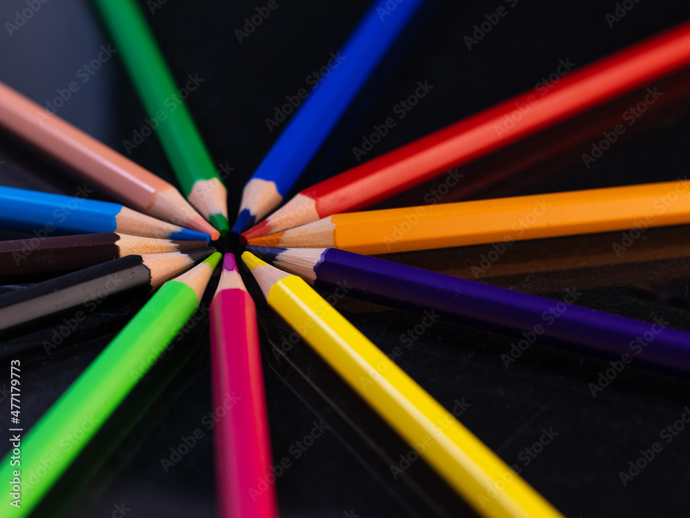 Group of colored pencils in a circle on a black background Group of colored pencils in a circle on a black background