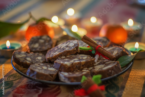 Christmas Cookies. Stack of chocolate chip cookies, cinnamon, anise, various Christmas decorations and lit candles. Selective focus. photo