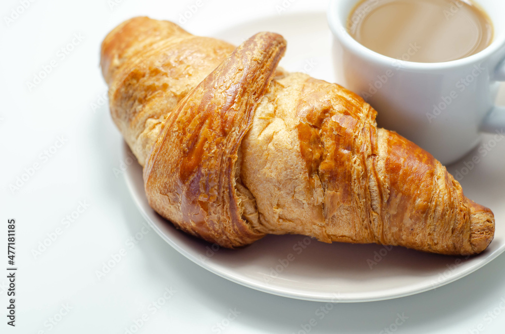 Croissant with chocolate on a plate with coffee in a cup