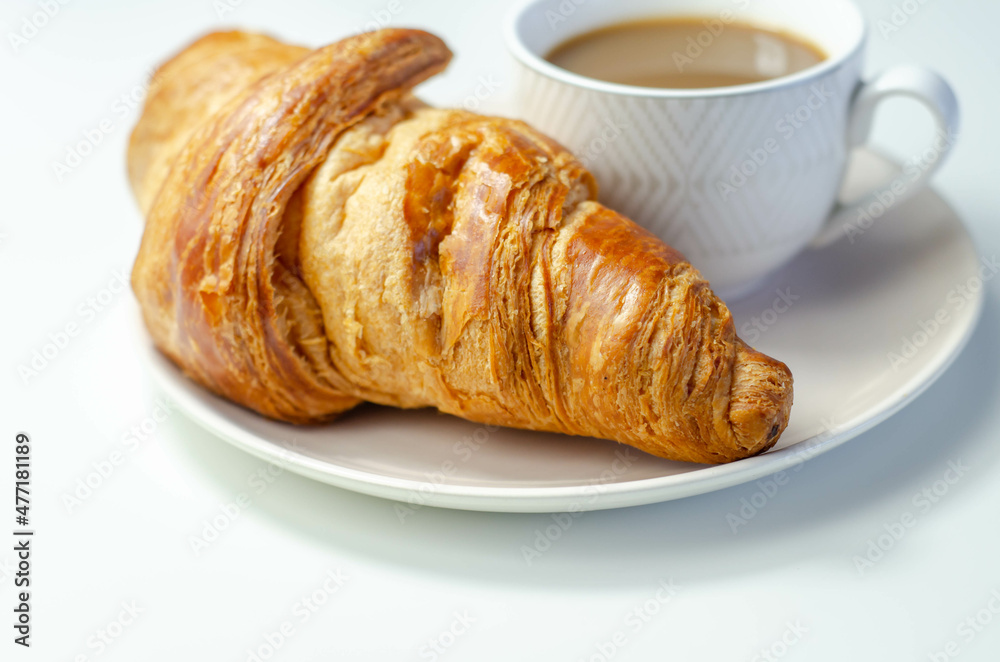Croissant with chocolate on a plate with coffee in a cup Croissant with chocolate on a plate with coffee in a cup