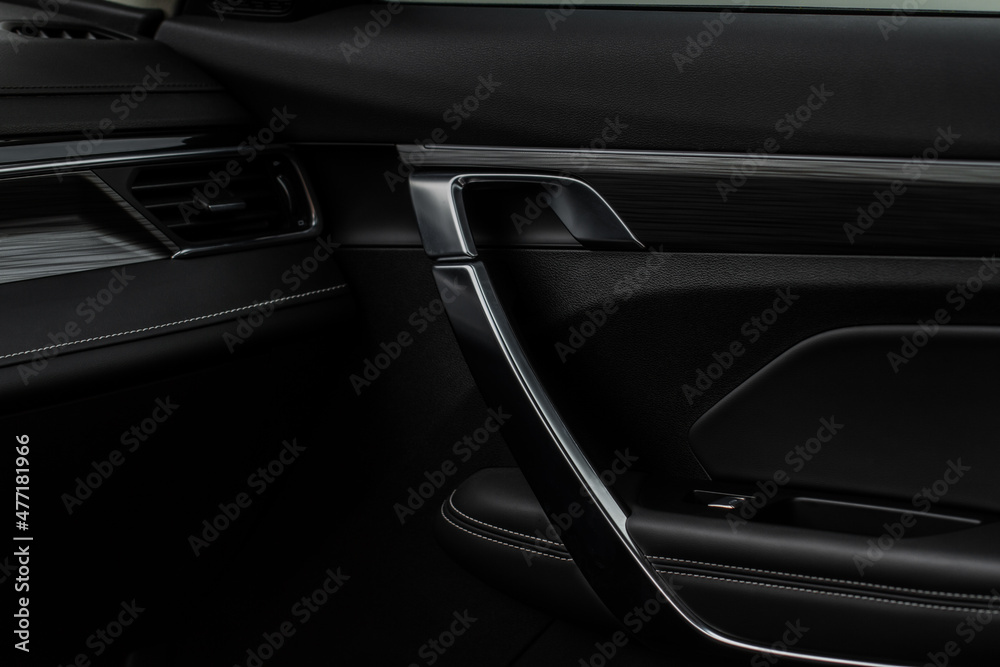 Modern car interior door handle close up. Metallic Car door opener handle inside.