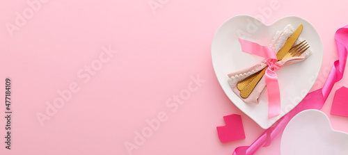 Beautiful table setting for Valentine's Day on pink background with space for text
