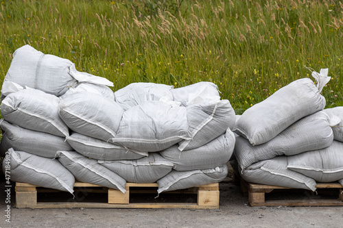 Yellow wooden Pallets with white sandbags are outside for building photo