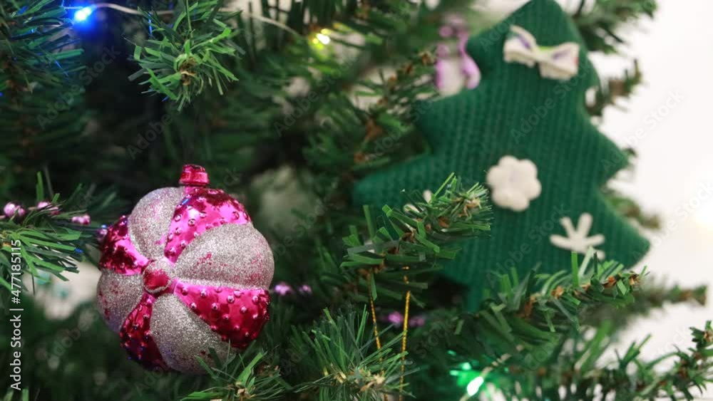 a garland flashes on an artificial Christmas tree decorated with toys and balloons a garland flashes on an artificial Christmas tree decorated with toys and balloons