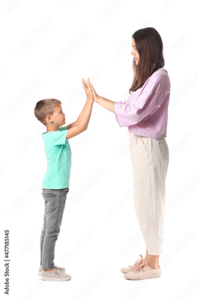 Little boy and his older sister giving each other high-five on white background Little boy and his older sister giving each other high-five on white background