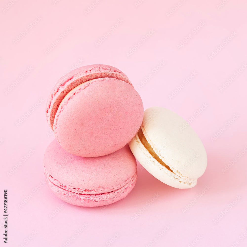 Fototapeta premium Three macaroons close-up lying on pink background
