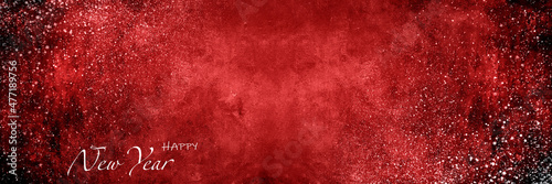 Red Christmas background with New Year greetings inscription and snow splashes on it.