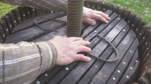 Close up men's hands assemble a wooden press for harvesting apple juice cider alcohol. Pressing fresh apples in bucket to produce in village. Fruit packaging warehouse, food processing 4k