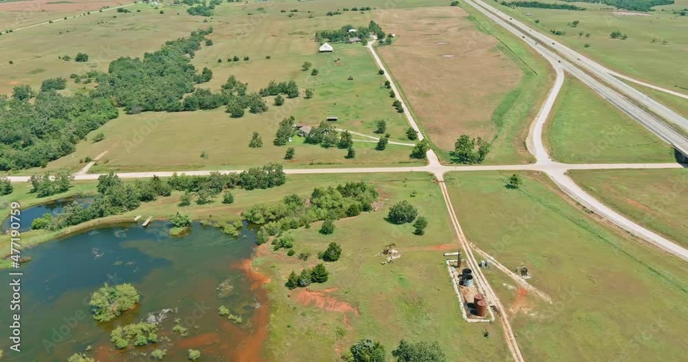 Aerial view of oil pump in the countryside the small pond near historic road 66 in Clinton Oklahoma on aerial view landscape Aerial view of oil pump in the countryside the small pond near historic road 66 in Clinton Oklahoma on aerial view landscape