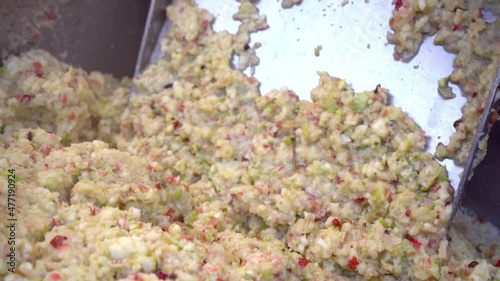 Closeup crushing in grinding box before squeezing in wooden press to produce cider in village. Fruit vitamin paste. Raw vegan vegetarian healthy food concept 4k