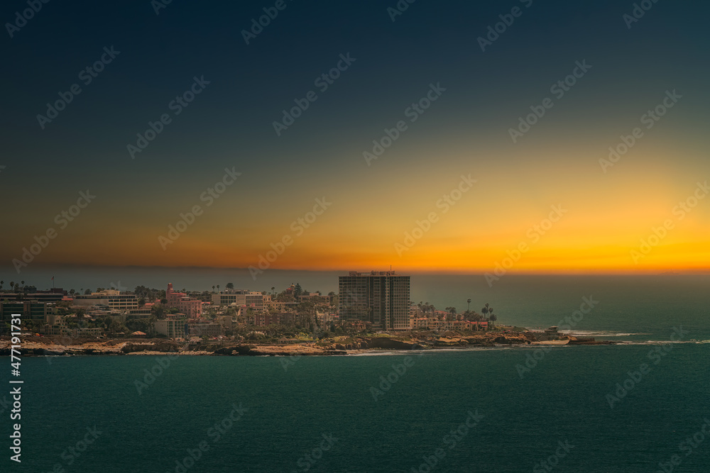 Fototapeta premium 2021-12-27 THE LA JOLLA SHORELINE AND THE VILLAGE AREA WITH A SETTING SUN AND A CLEAR SKY