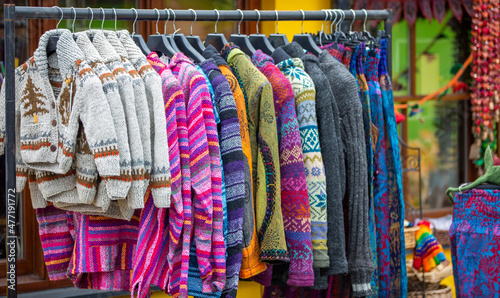 clothes rack of colorful jumpers and sweaters 