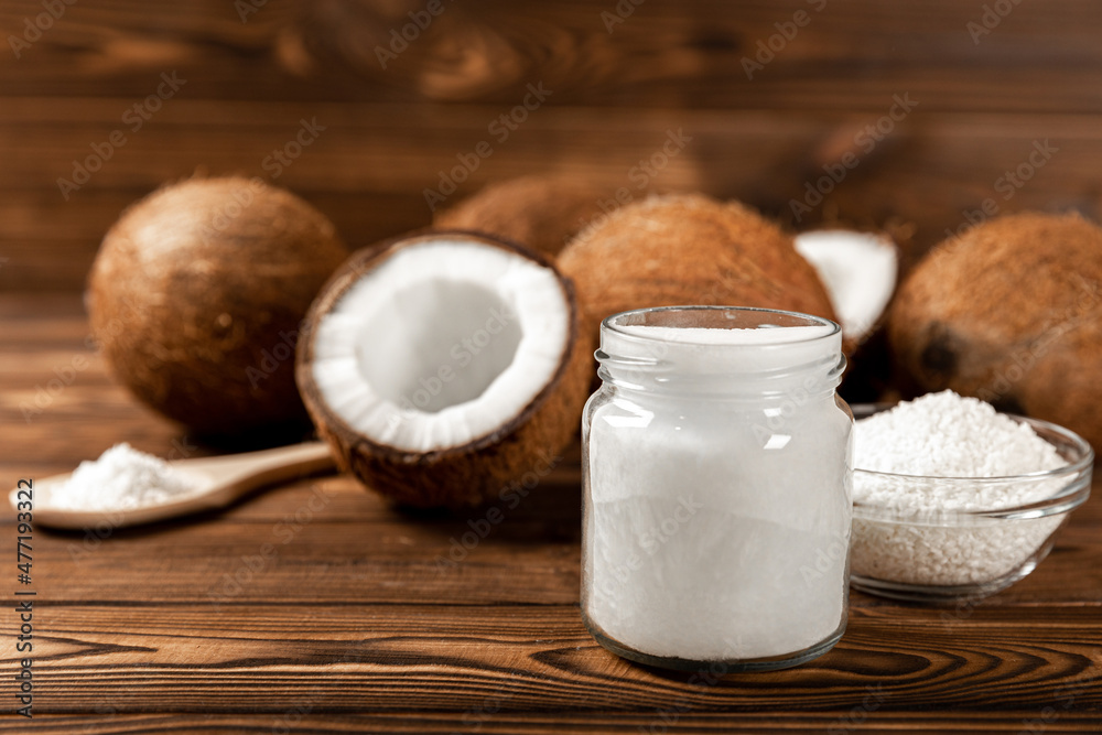 coconuts, coconut flakes and coconut oil on a wooden background. Close-up. coconuts, coconut flakes and coconut oil on a wooden background. Close-up.