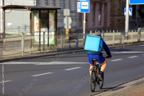 Kurier na rowerze, dostarcza jedzenie na ulicach miasta. 