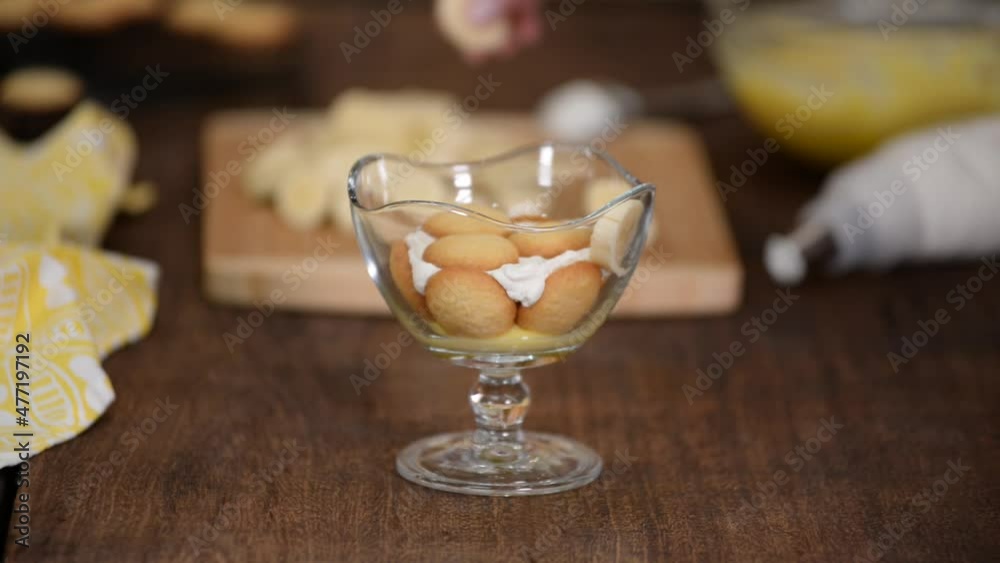 custom made wallpaper toronto digitalWoman hands making a banana pudding in glass dessert cup.